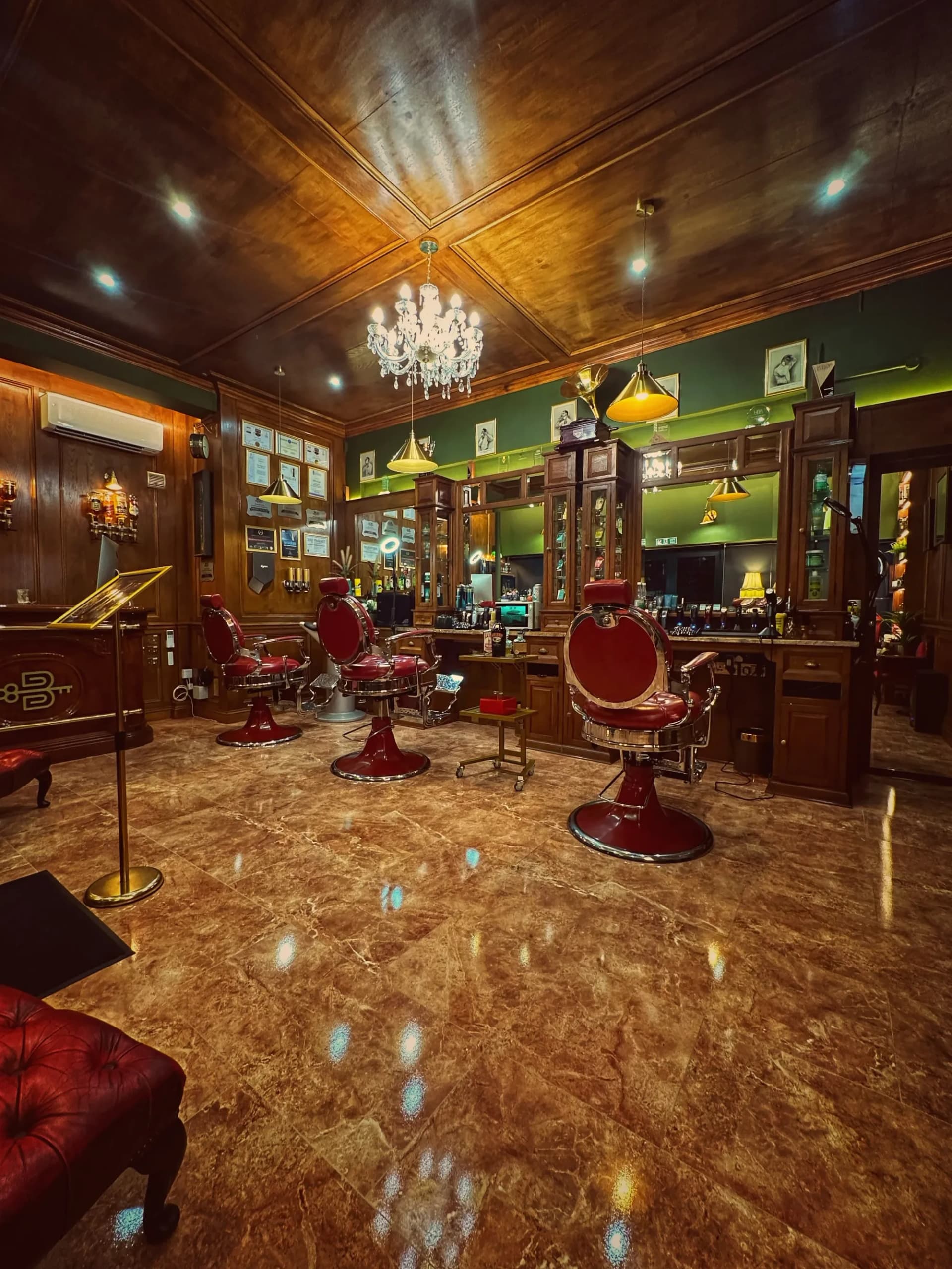 Inside the Boardroom — barber chairs beneath the chandelier